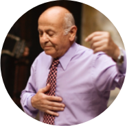 A man in a purple shirt with a tie smiling and dancing.